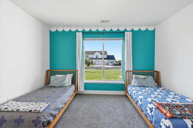 1422 West 3410th Street South Logan, UT 84321 - Photo 22 of 33 Bright room featuring a large central window with exterior views, vibrant accent wall, and neutral carpeting