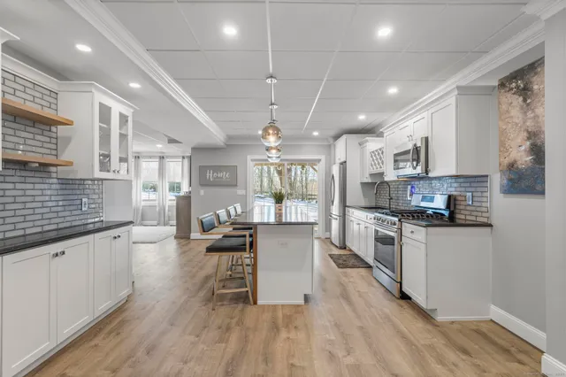 a large kitchen with stainless steel appliances granite countertop a lot of counter space and wooden floors