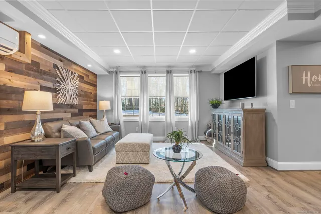 a living room with furniture a flat screen tv and a large window