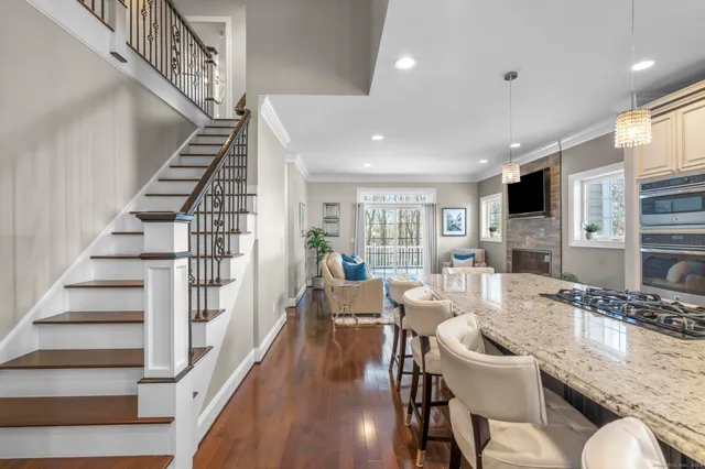 a view of a dining room with furniture a fireplace and wooden floor