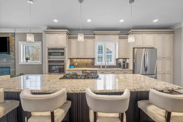 a kitchen with a dining table chairs sink and refrigerator