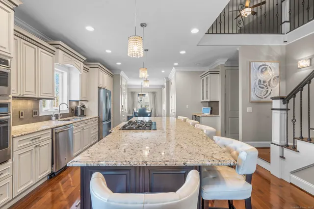 a kitchen with granite countertop kitchen island stainless steel appliances a sink and counter space