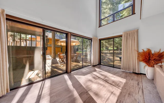 a view of a bedroom with wooden floor and balcony