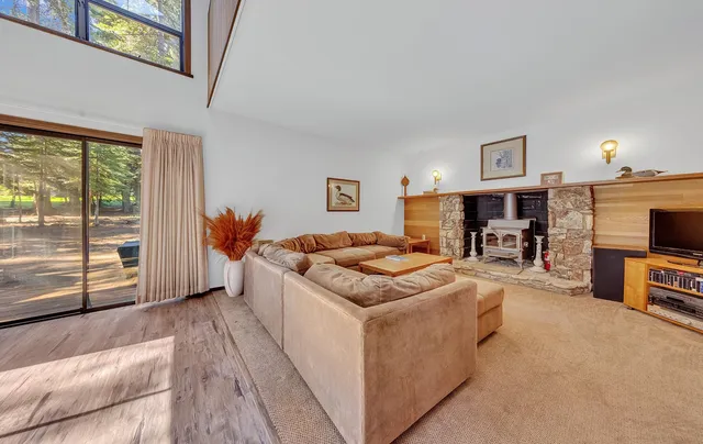 a living room with furniture a flat screen tv and a table