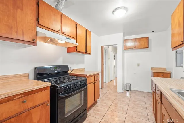 a kitchen with granite countertop a sink and a stove top oven