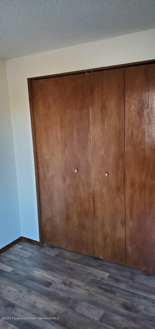 1012-1018 Stillwell Avenue Rifle, CO 81650 - Photo 12 of 15 a view of an empty room with wooden floor and a window