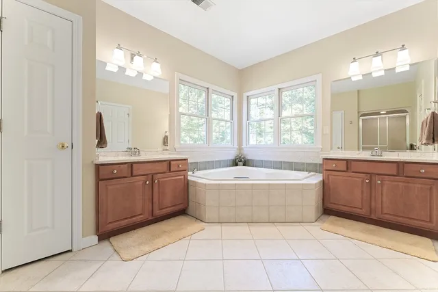 a bathroom with a granite countertop bathtub sink and mirror