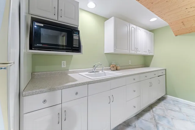 a kitchen with white cabinets stainless steel appliances and sink