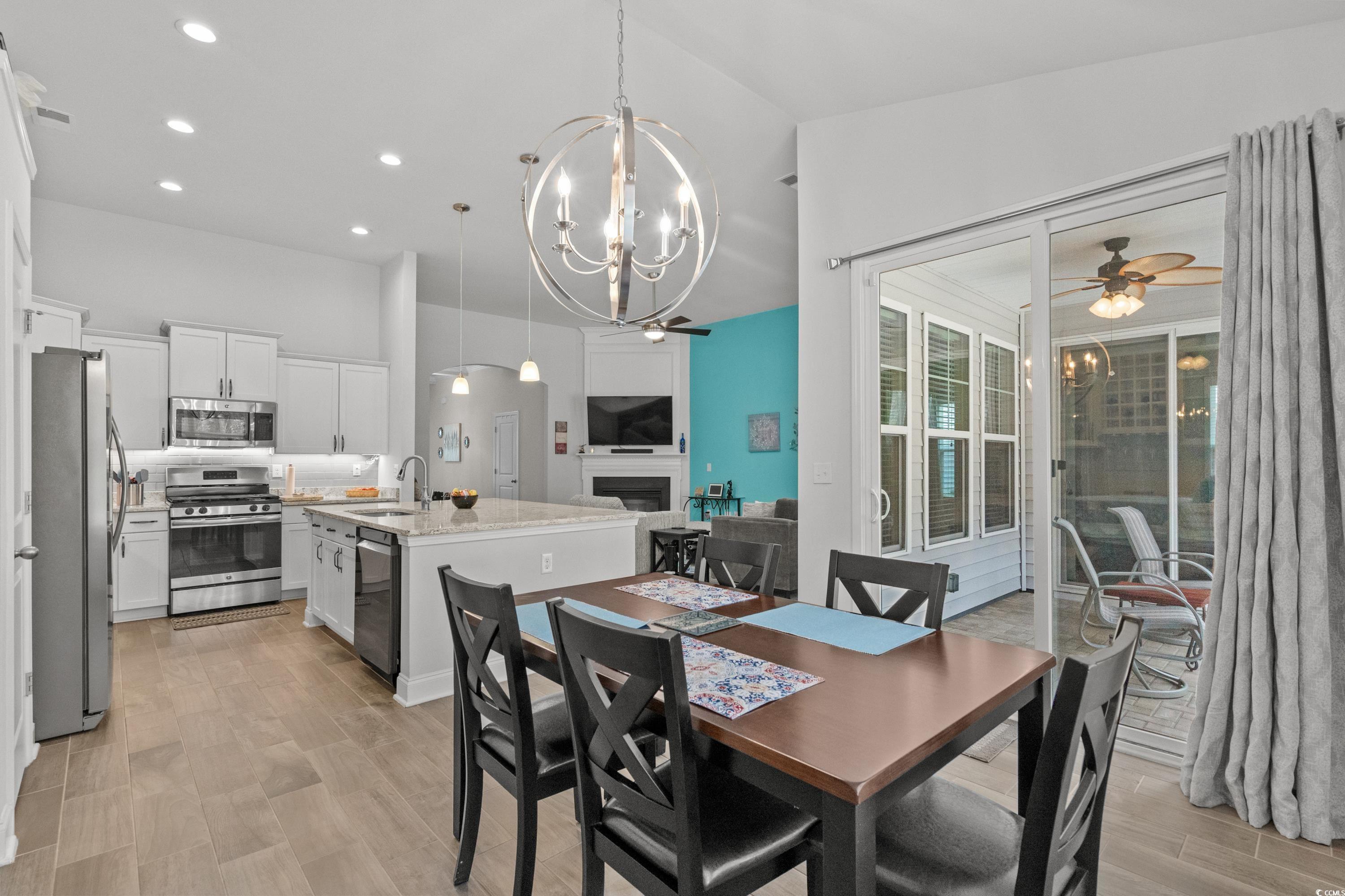 4284 Livorn Loop Myrtle Beach, SC 29579 - Photo 13 of 40 Dining space featuring a fireplace, light wood-sty