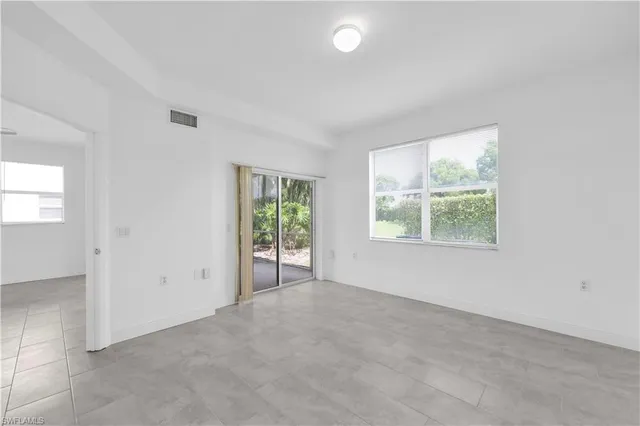 an empty room with windows and closet