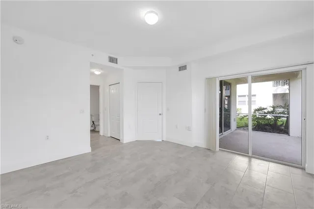an empty room with sliding glass door and shower