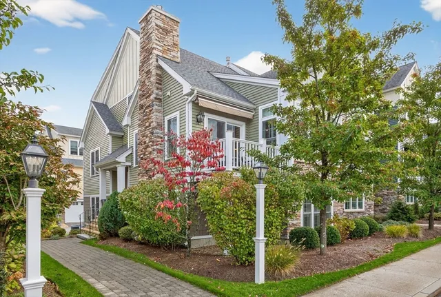 a front view of a house with a yard and potted plants