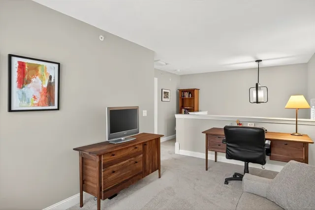 a view of a workspace with furniture and a window
