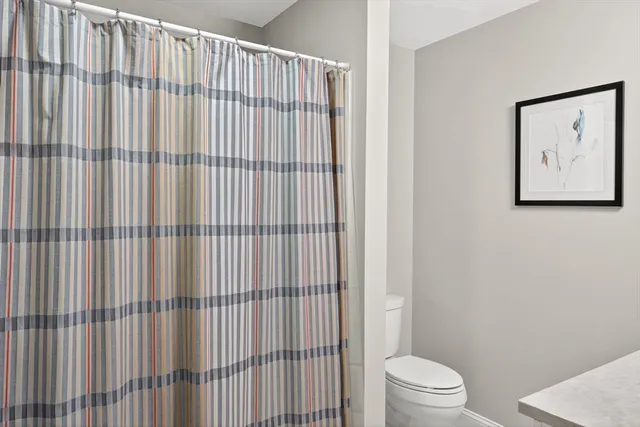 a bathroom with a toilet and a shower curtain