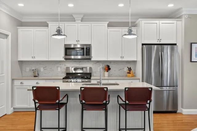 a kitchen with stainless steel appliances a stove refrigerator sink and cabinets