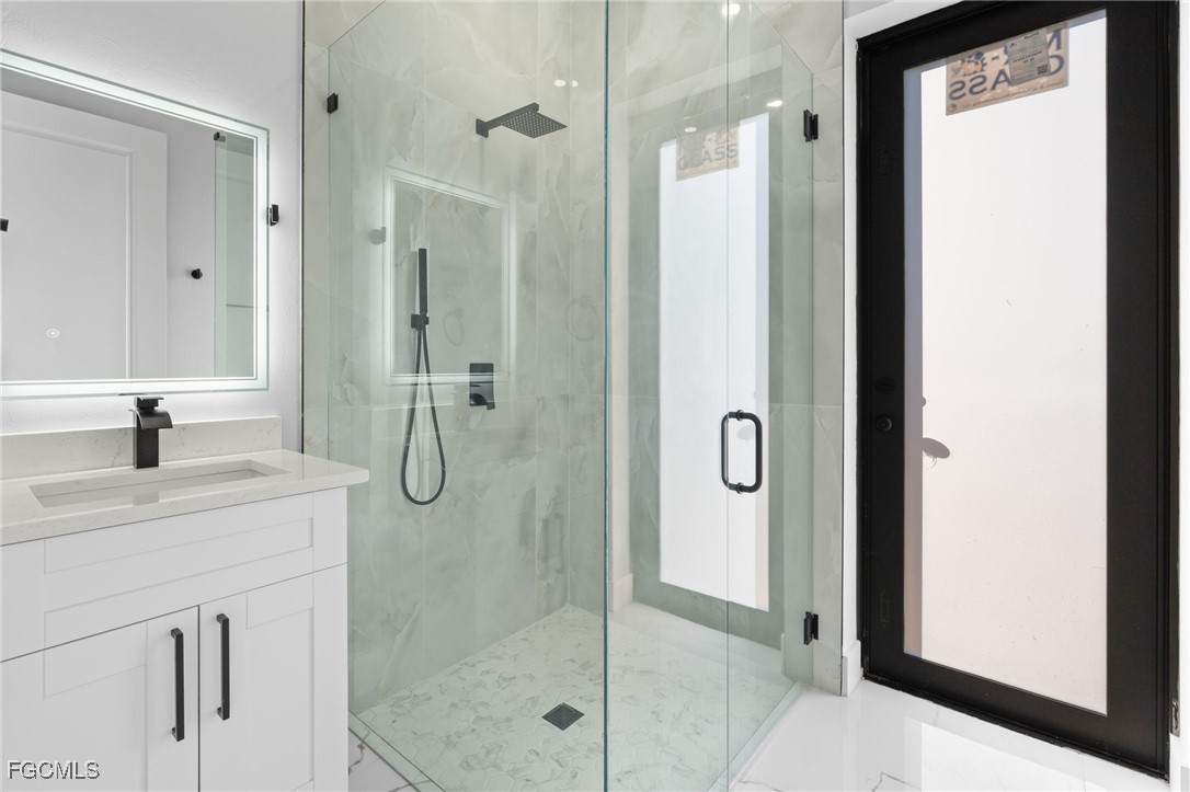 2603 3rd Street Southwest Lehigh Acres, FL 33976 - Photo 20 of 28 a bathroom with a granite countertop shower mirror and a sink