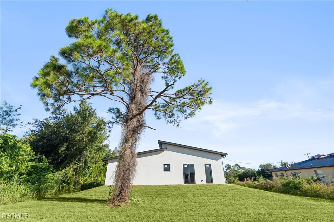 2603 3rd Street Southwest Lehigh Acres, FL 33976 - Photo 22 of 28 a house with green field in front of it