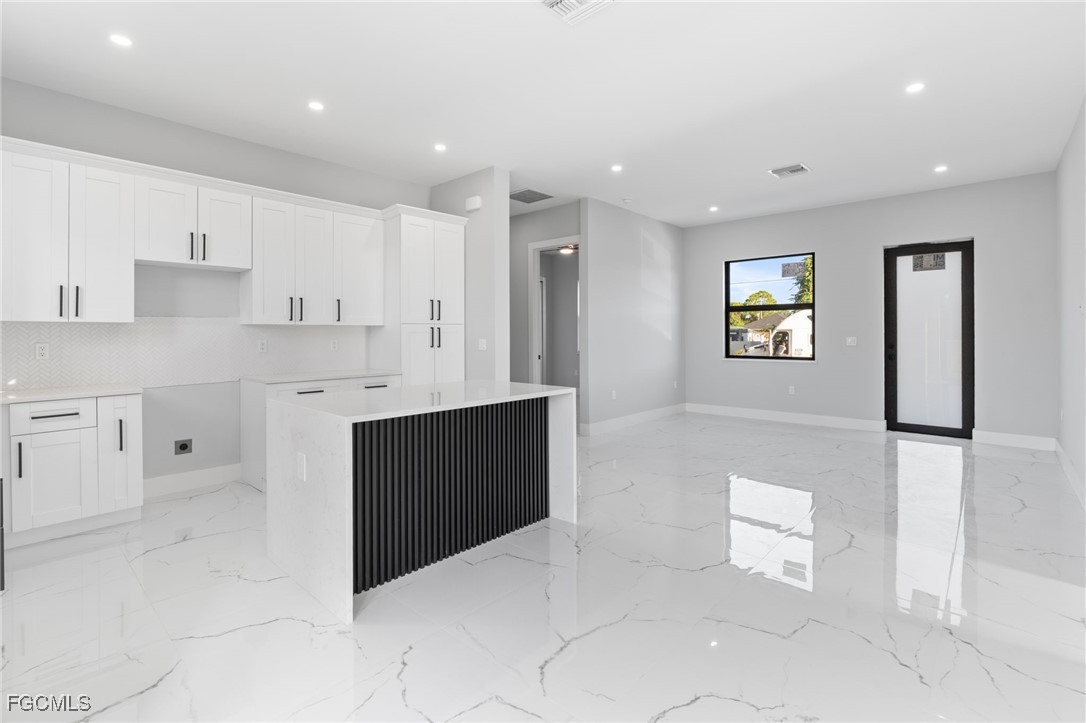 2603 3rd Street Southwest Lehigh Acres, FL 33976 - Photo 8 of 28 a kitchen with stainless steel appliances a refrigerator sink and stove