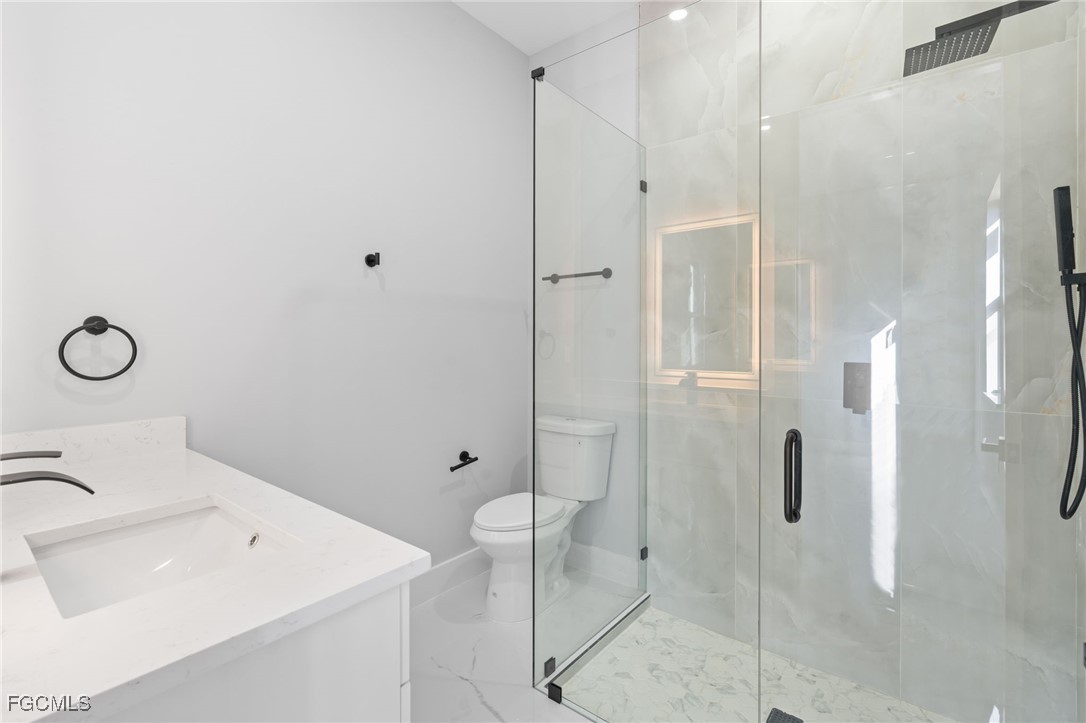 2603 3rd Street Southwest Lehigh Acres, FL 33976 - Photo 10 of 28 a bathroom with a shower sink and mirror