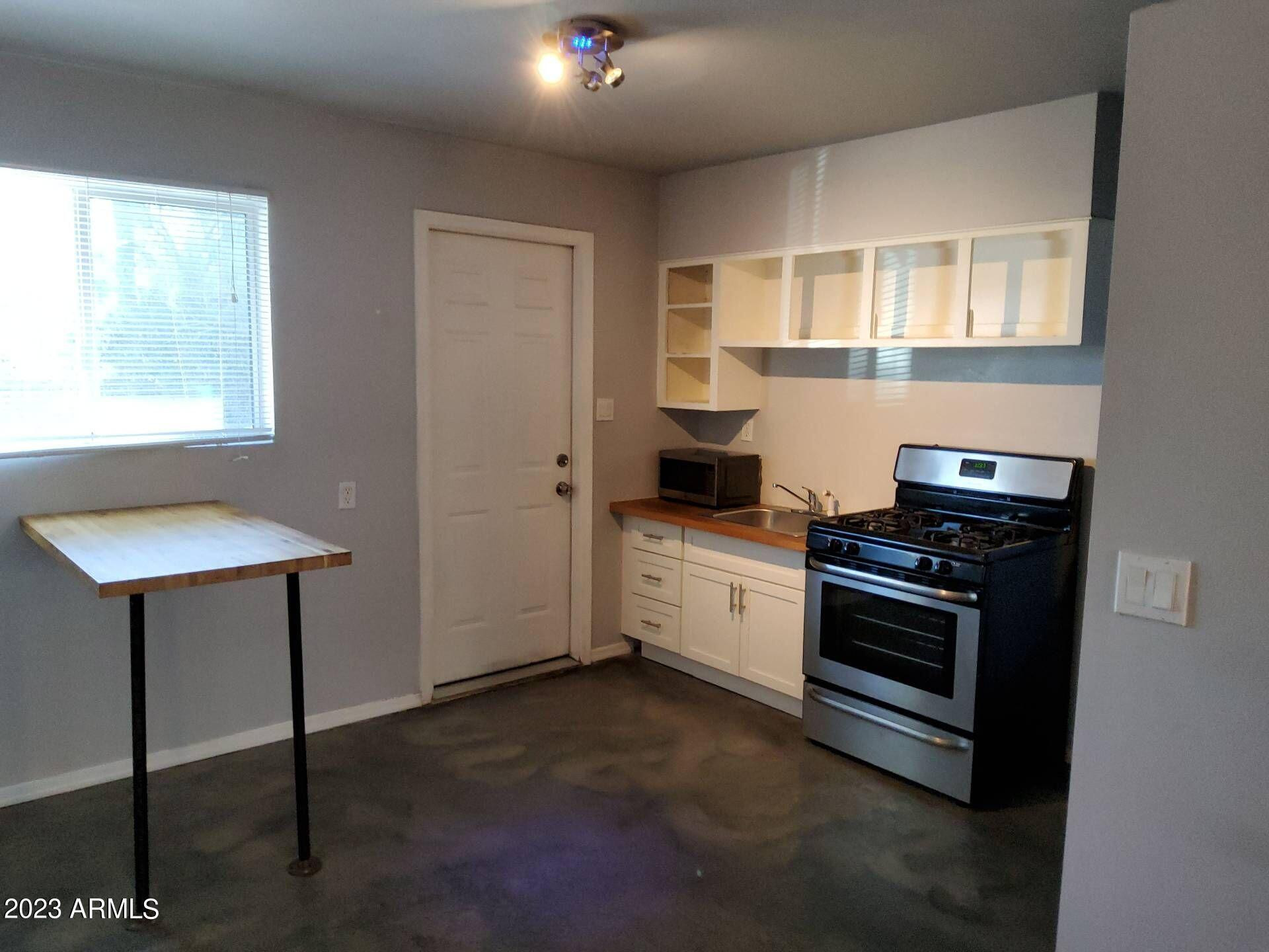3427 North 12th Place, Unit 1 Phoenix, AZ 85014 - Photo 2 of 7 a kitchen with stainless steel appliances a stove a sink and a microwave