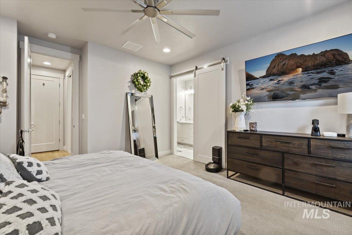 2616 West Neff Street Boise, ID 83702 - Photo 18 of 36 Bedroom with light carpet, ceiling fan, a barn door, connected bathroom, and recessed lighting