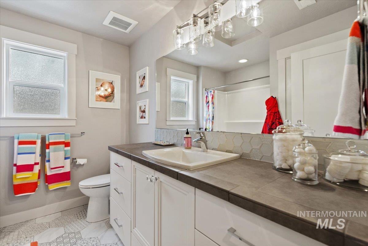 2616 West Neff Street Boise, ID 83702 - Photo 28 of 36 Bathroom featuring vanity, a shower with shower curtain, light tile patterned floors, and decorative backsplash