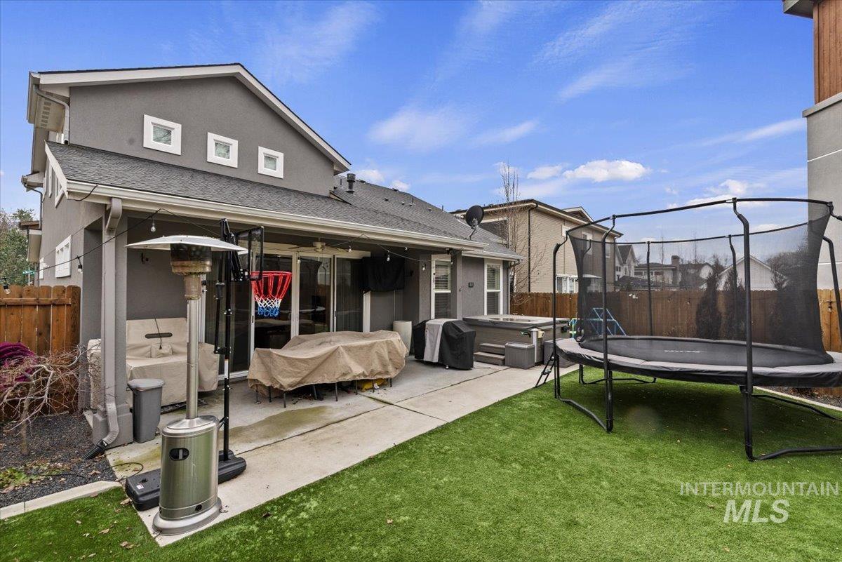 2616 West Neff Street Boise, ID 83702 - Photo 32 of 36 Back of house featuring a trampoline, a fenced backyard, a patio area, roof with shingles, and a hot tub