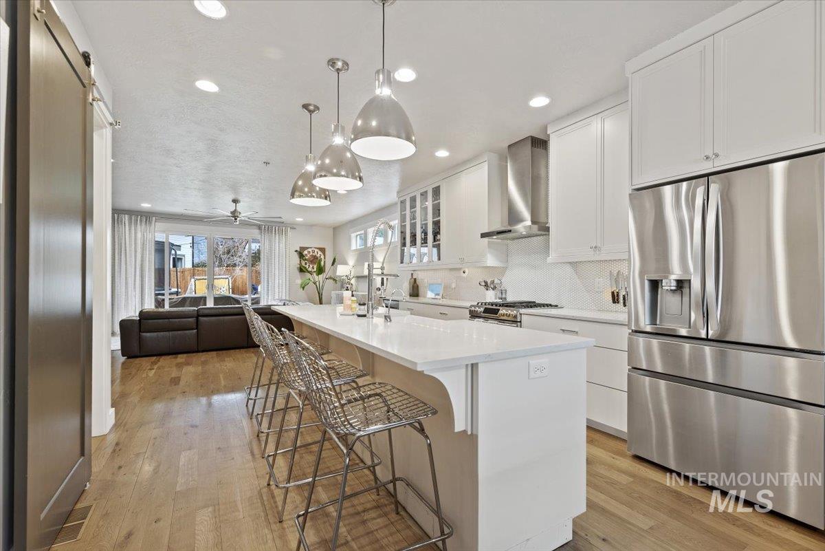 2616 West Neff Street Boise, ID 83702 - Photo 9 of 36 Kitchen with stainless steel appliances, glass insert cabinets, white cabinets, a kitchen breakfast bar, and a center island with sink
