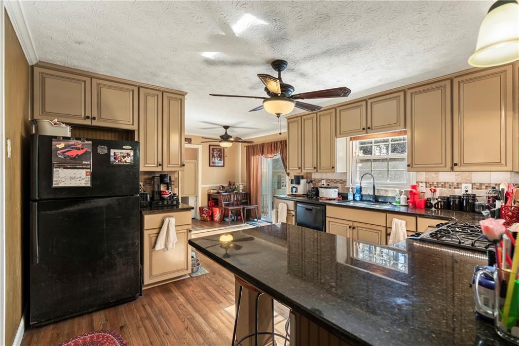 1500 Lake Dow Road McDonough, GA 30252 - Photo 14 of 42 a kitchen with stainless steel appliances granite countertop a refrigerator a stove top oven a sink dishwasher and white cabinets with wooden floor