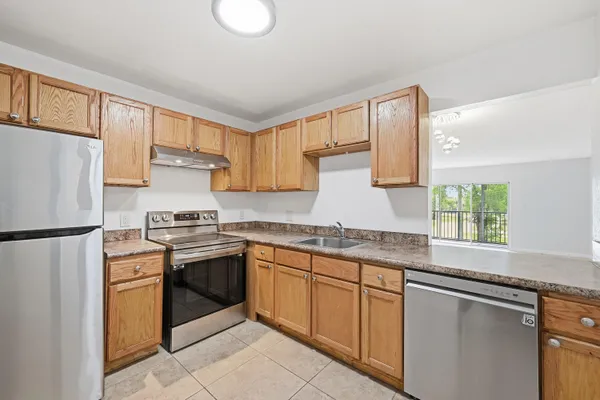 a kitchen with stainless steel appliances granite countertop a stove a sink and a refrigerator