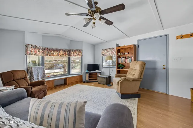 a living room with furniture kitchen view and a flat screen tv