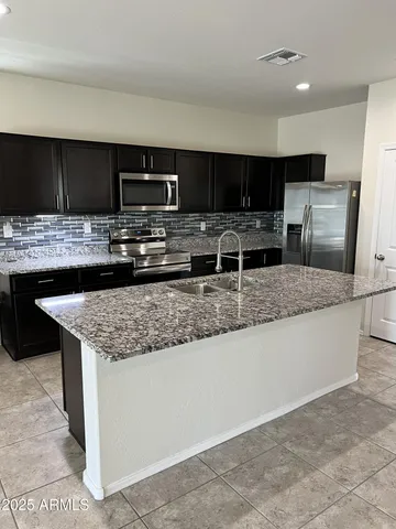 a kitchen with kitchen island granite countertop a sink and counter space