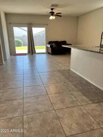 a view of a livingroom with a ceiling fan and window