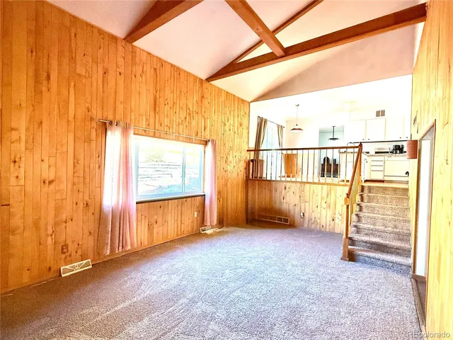 a view of a big room with wooden floor and windows