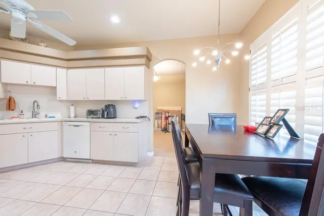 a kitchen with a dining table chairs sink and cabinets