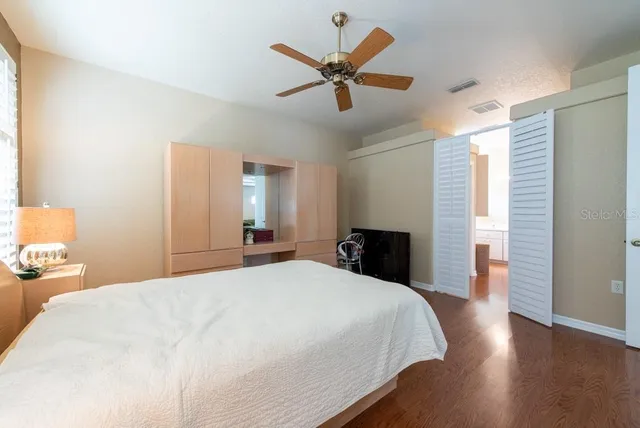 a bed room with a bed and a ceiling fan
