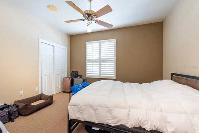 a bedroom with a bed a chandelier and a window
