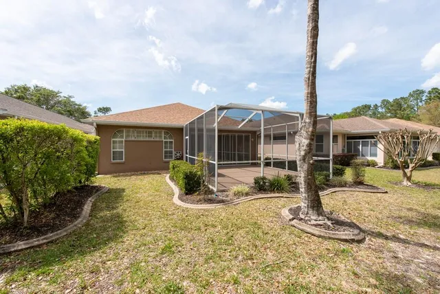 a view of a house with backyard and sitting area