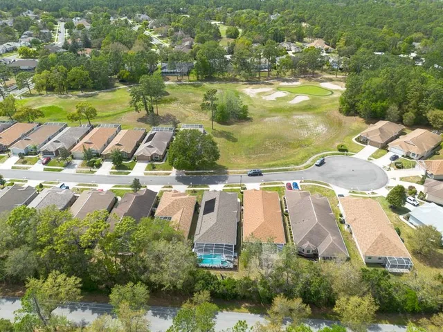 an aerial view of residential houses with outdoor space and swimming pool