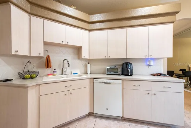 a kitchen with white cabinets and white appliances