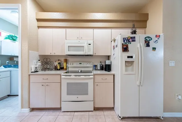 a kitchen with white cabinets and white appliances