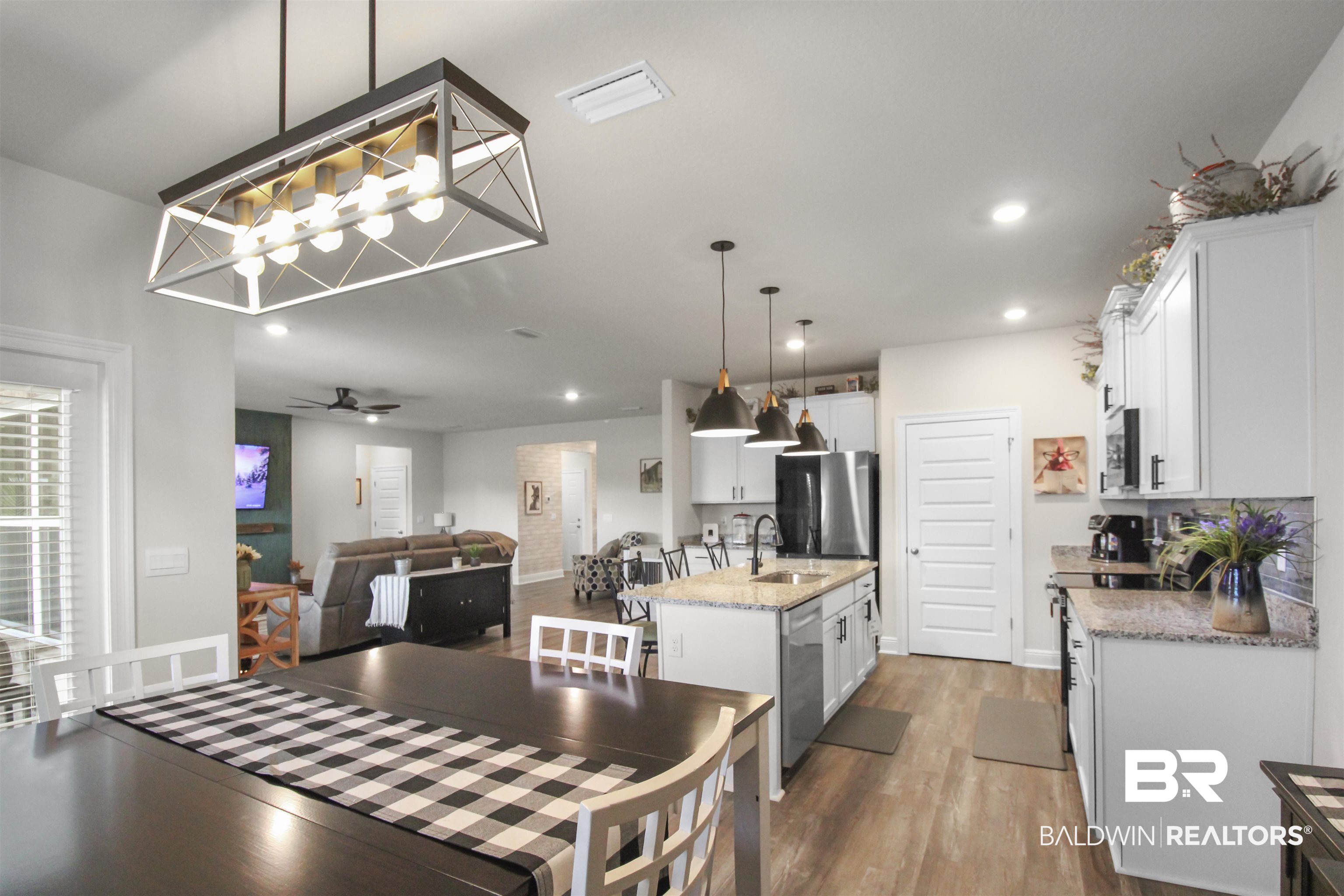 12523 Pheasant Run Elberta, AL 36530 - Photo 11 of 43 Kitchen featuring light stone countertops, white cabinets, a kitchen island with sink, stainless steel appliances, and pendant lighting