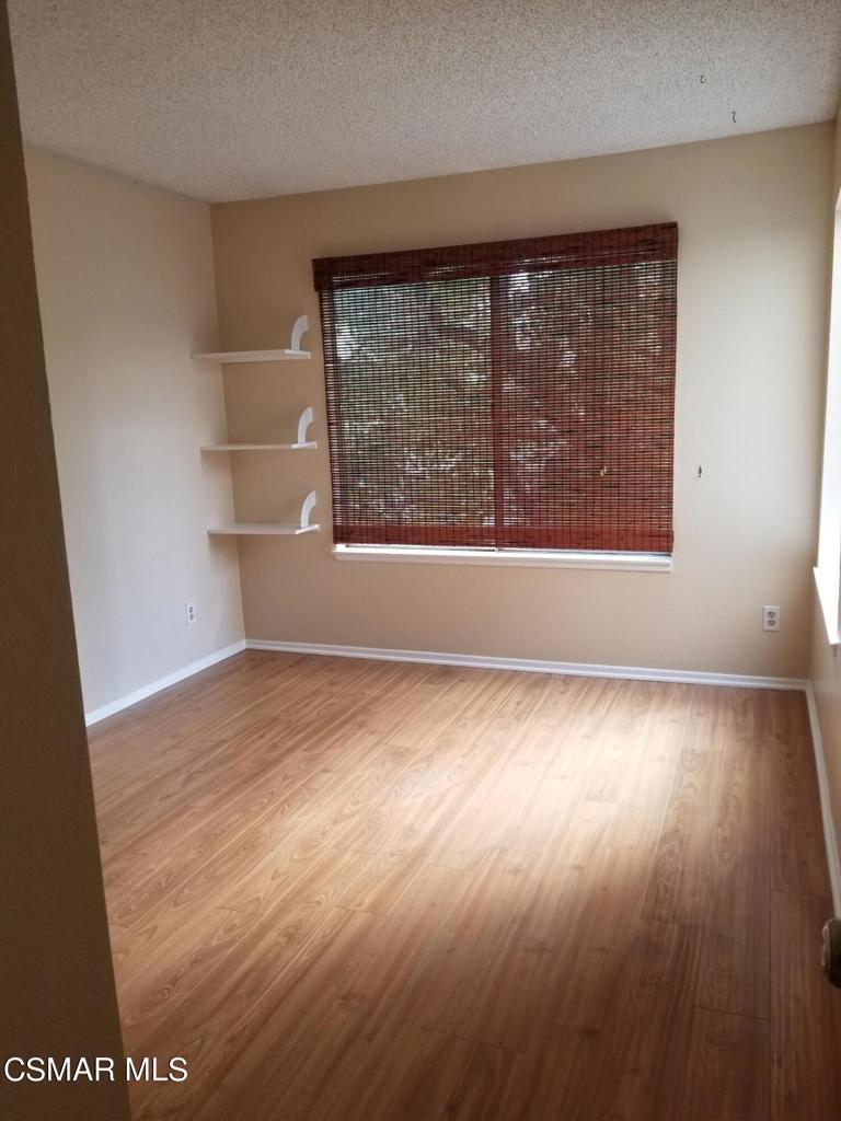 1754 Sinaloa Road, Unit 275 Simi Valley, CA 93065 - Photo 11 of 18 an empty room with wooden floor and windows