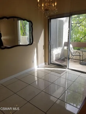 a view of an empty room with a floor to ceiling window and potted plants
