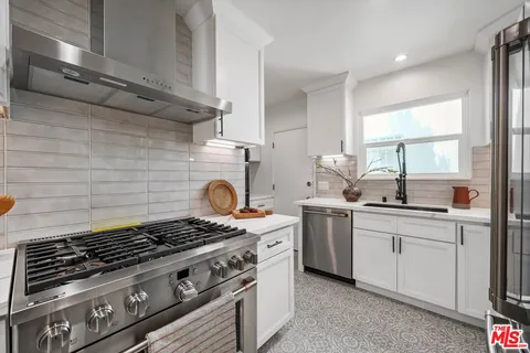 a kitchen with a stove and white cabinets