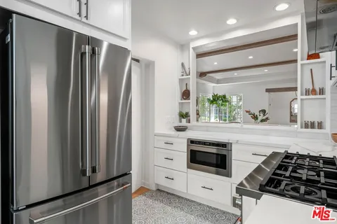 a kitchen with white cabinets and appliances