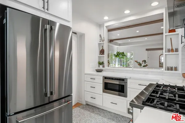 a kitchen with white cabinets and appliances