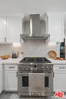 a stove top oven sitting inside of a kitchen