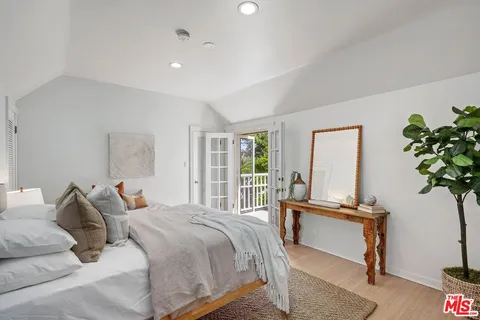 a bedroom with a bed and a potted plant