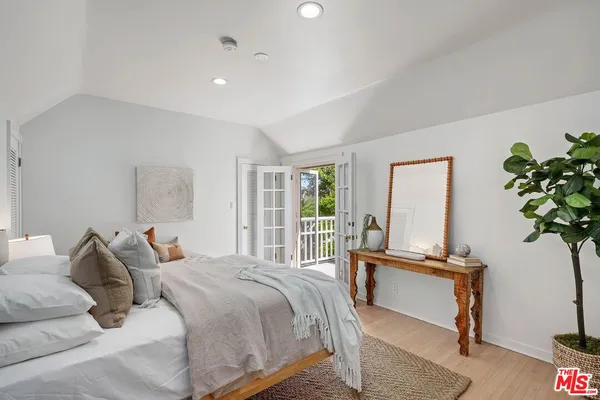 a bedroom with a bed and a potted plant